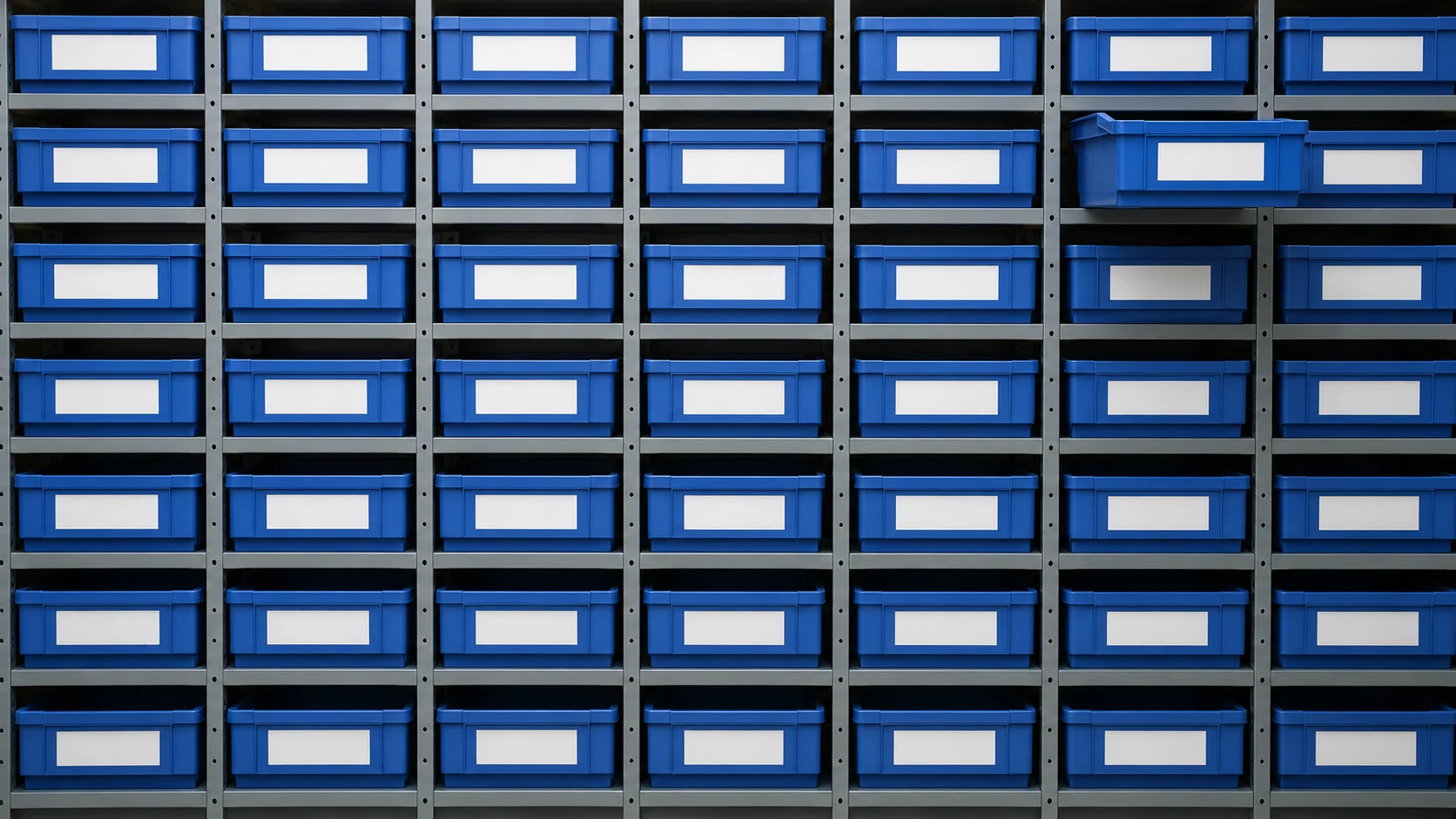 A wall of blue storage bins in a grid, one pulled forward